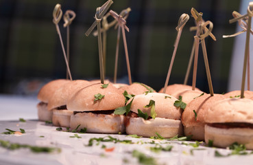 Miniburger mit frischen Kräutern auf Servierplatte