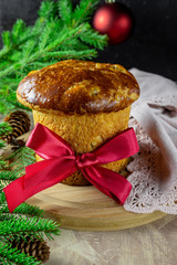 Panettone - Italian tradition festive baking. Wooden background with fir tree. Christmas.