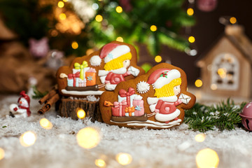 Holiday traditional food bakery. Gingerbread two chirstmas postman and sleigh with gifts in cozy warm decoration with garland lights