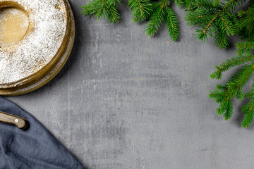 Christmas cake with pine branches on grey table. Happy new year concept