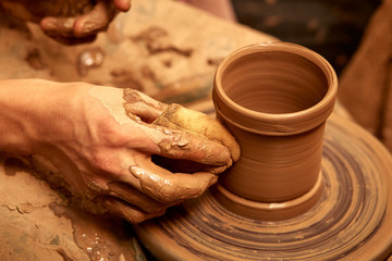 Man hands making clay jug macro. The sculptor in the workshop makes a jug out of earthenware closeup.