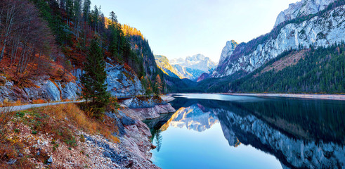 Beautiful Gosausee lake landscape with Dachstein mountains, forest, clouds and reflections in the...