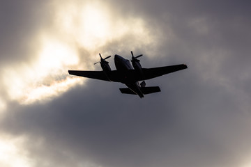 Avião bimotor decola sob céu nublado