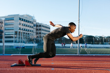 Black man running fast on stadium