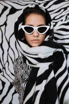 Elegant lady in zebra headscarf and sunglasses