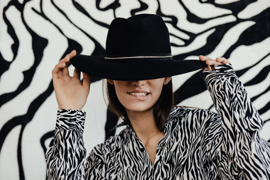 Stylish lady in hat biting lip