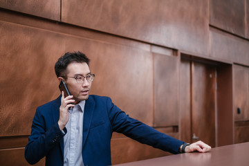 Business man standing in front of a brown wall