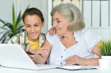 Close up portrait of grandmother with her grandson using laptop