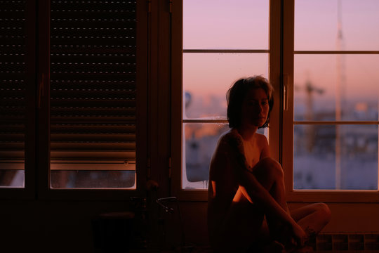 woman contemplating the sunrise naked