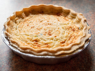 Quiche lorraine close up. French style pastry food. Sun flare.