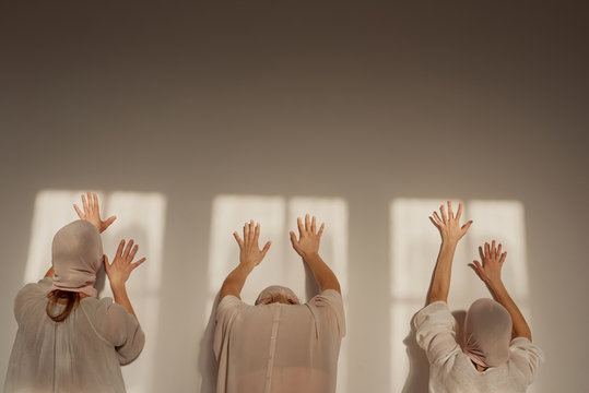 Rear view of women standing in front of wall