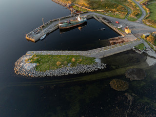 Small harbor with cargo ship and small boats. Aerial view. Kilmacduagh Galway bay. Ireland.