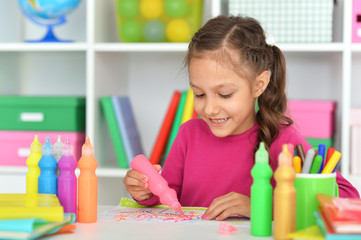 Portrait of cute smiling beautiful girl drawing at home