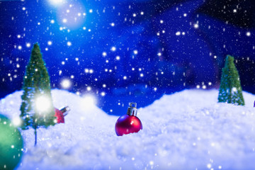 Naklejka na ściany i meble Christmas background with Christmas balls on snow over fir-tree, night sky and moon. Shallow depth of field. Christmas background. Fairy tale. Macro. Artificial magic dreamy world.