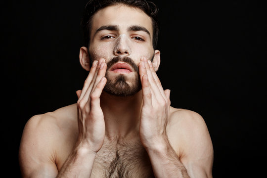 Beauty shot man exfoliating face