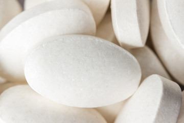 Fototapeta na wymiar Group of white medical supplement pills, macro image