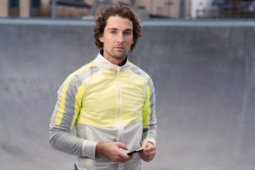Portrait of attractive man holding smart phone in stylish active wear