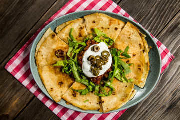 tortilla with tomato sauce, olives and sour cream