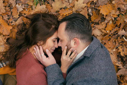 portrait couple hugging in leaves from above angle