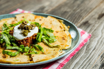 tortilla with tomato sauce, olives and sour cream