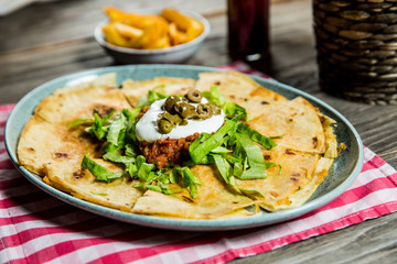 tortilla with tomato sauce, olives and sour cream