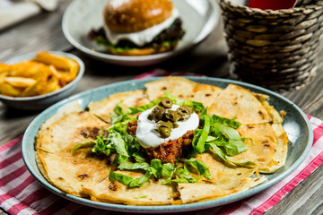 tortilla with tomato sauce, olives and sour cream