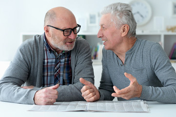 Close up portrait of two senior men sitting at table
