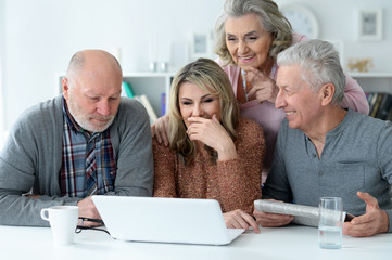 Close up portrait of two senior couples sitting at table