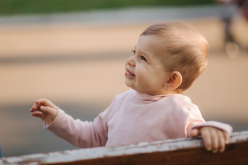 Close up of beautiful little smiled girl. Happy baby girl in autumn park. Ten month baby smile