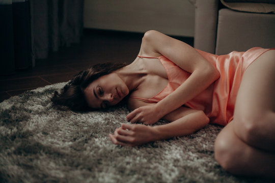 girl in a night dress lies on the carpet