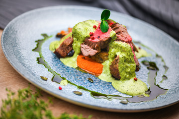 Steak with green sauce and pumpkin