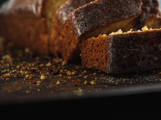 Rectangular loaf cut into pieces with a white sprinkle is on a rusty protvin.