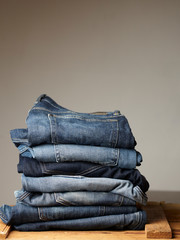 Stack of various blue jeans on black background. Beauty and fashion, clothing concept. Detail of nice blue jeans. Jeans texture or denim background. Collection of jeans. the blue jeans fabric details
