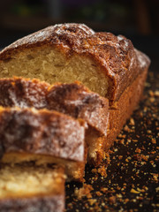 Rectangular loaf cut into pieces with a white sprinkle is on a rusty protvin.
