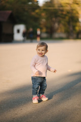 Fototapeta premium Adorable little girl walk in the parl in october. Cute ten month baby walk. Beautiful happy girl. Autumn mood