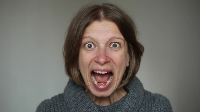 Portrait of an emotional annoyed woman screaming at camera.