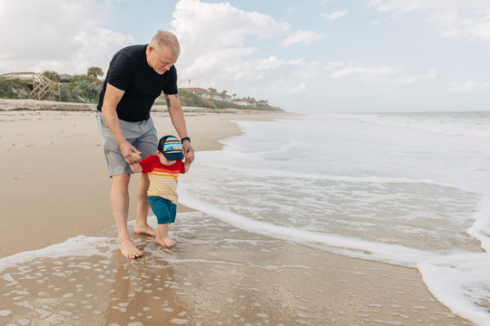Grandfather with toddler on the beach