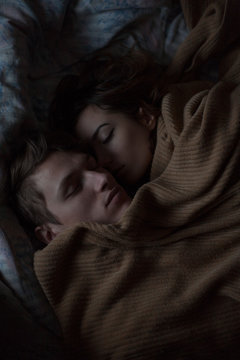 close-up portrait of a guy and a girl lying on the bed