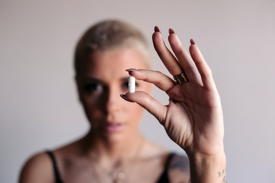 Woman holding a white pill