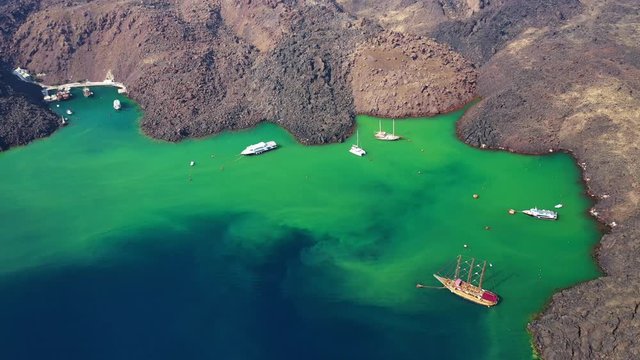 Aerial drone video of volcanic islet of Kameni in iconic Santorini island, Cyclades, Greece
