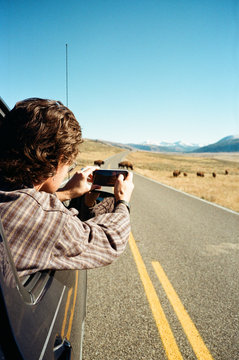 young man takes picture out car window