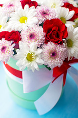 Beautiful red roses and delicate chrysanthemums in mint hat box.