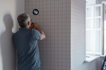 Man preparing wall for appliance installation