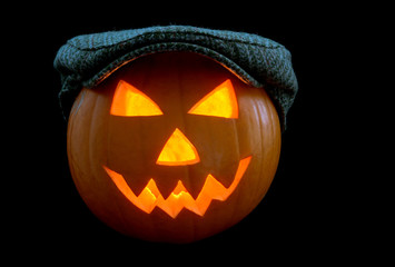 Fototapeta premium Halloween Pumpkin Lantern Wearing a Cap on a Black Background
