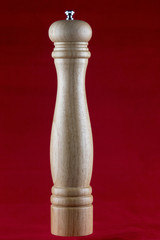 Wooden Pepper Mill on a Red Background
