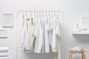 Cloakroom interior with clothes in white color