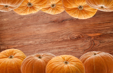 A row of festive Halloween pumpkins on a background of wooden boards for installation and creativity
