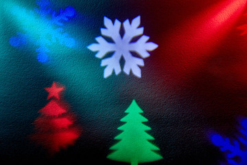 Fototapeta na wymiar Two rays of light on a black background. Colored snowflakes and christmas trees