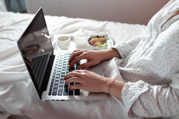 Woman lying in bed using her laptop