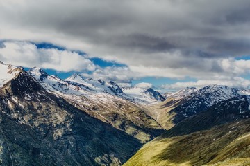 Alpy w Tyrolu austriackim, letni krajobraz alpejski, oświetlona dolina górska i szczyty pokryte śniegiem